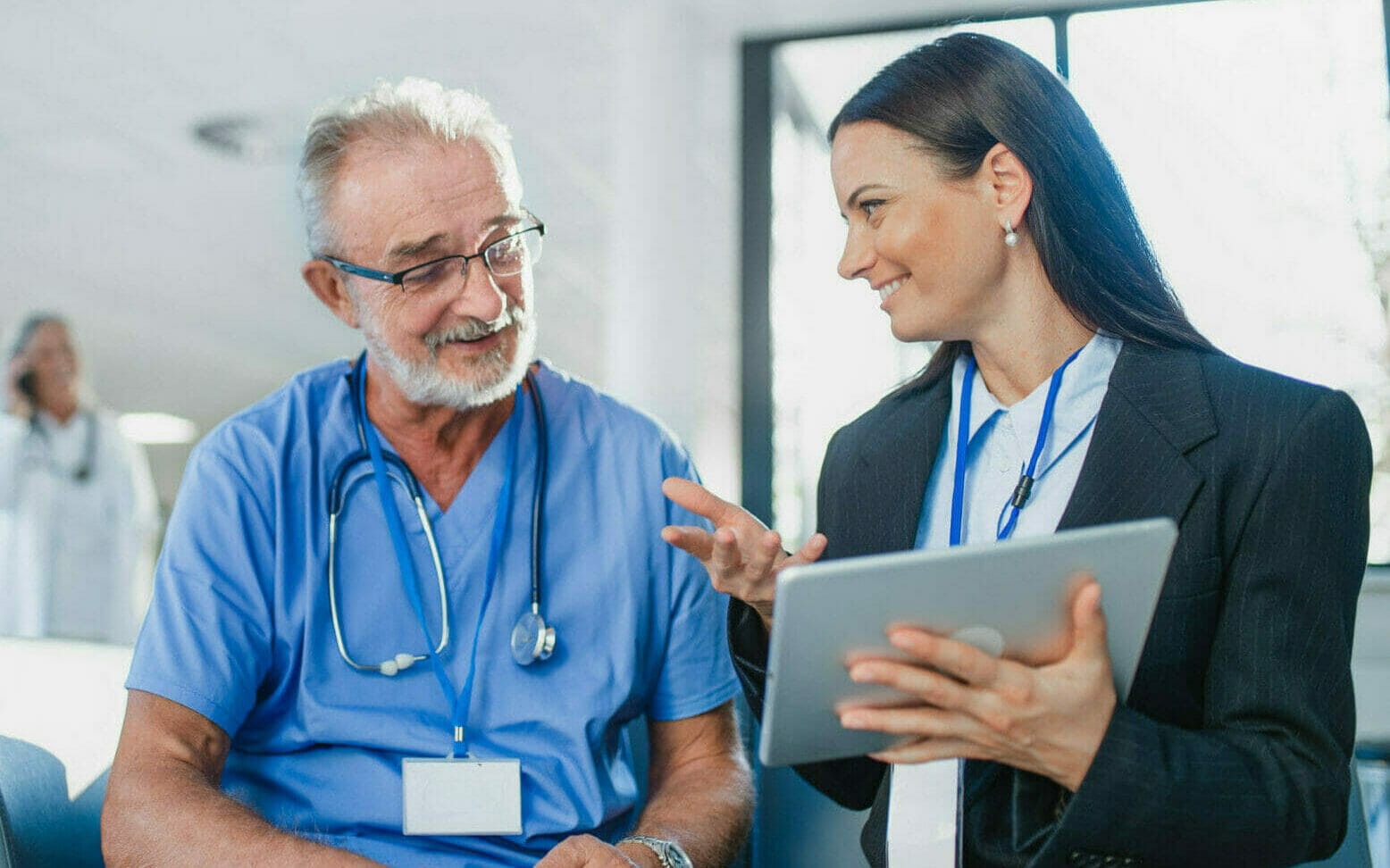 Young business woman shaking hand with elderly doctor.